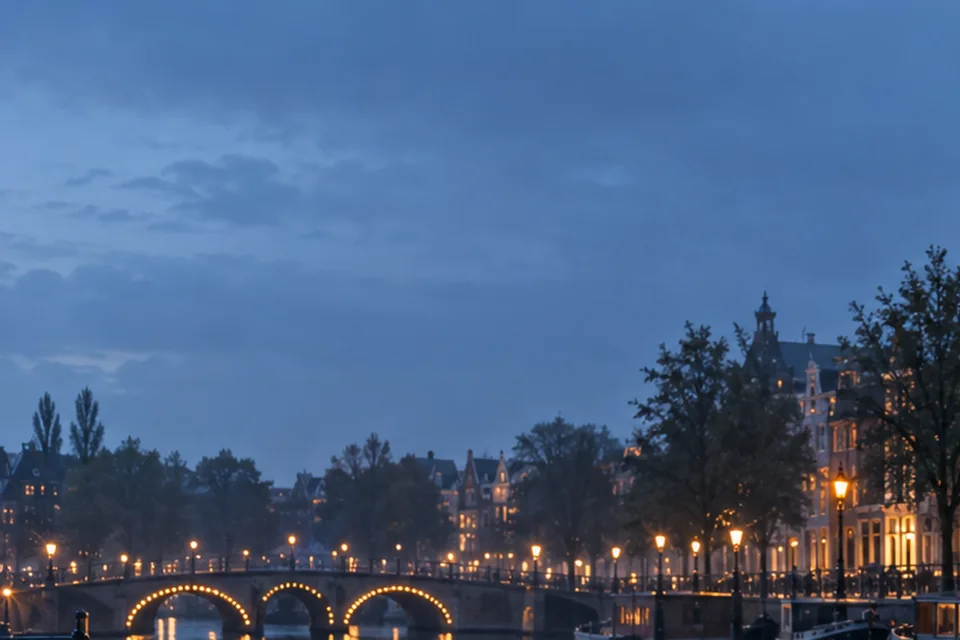Avondlicht langs een Nederlandse gracht, als redactionele sfeer voor de Amsterdamse route